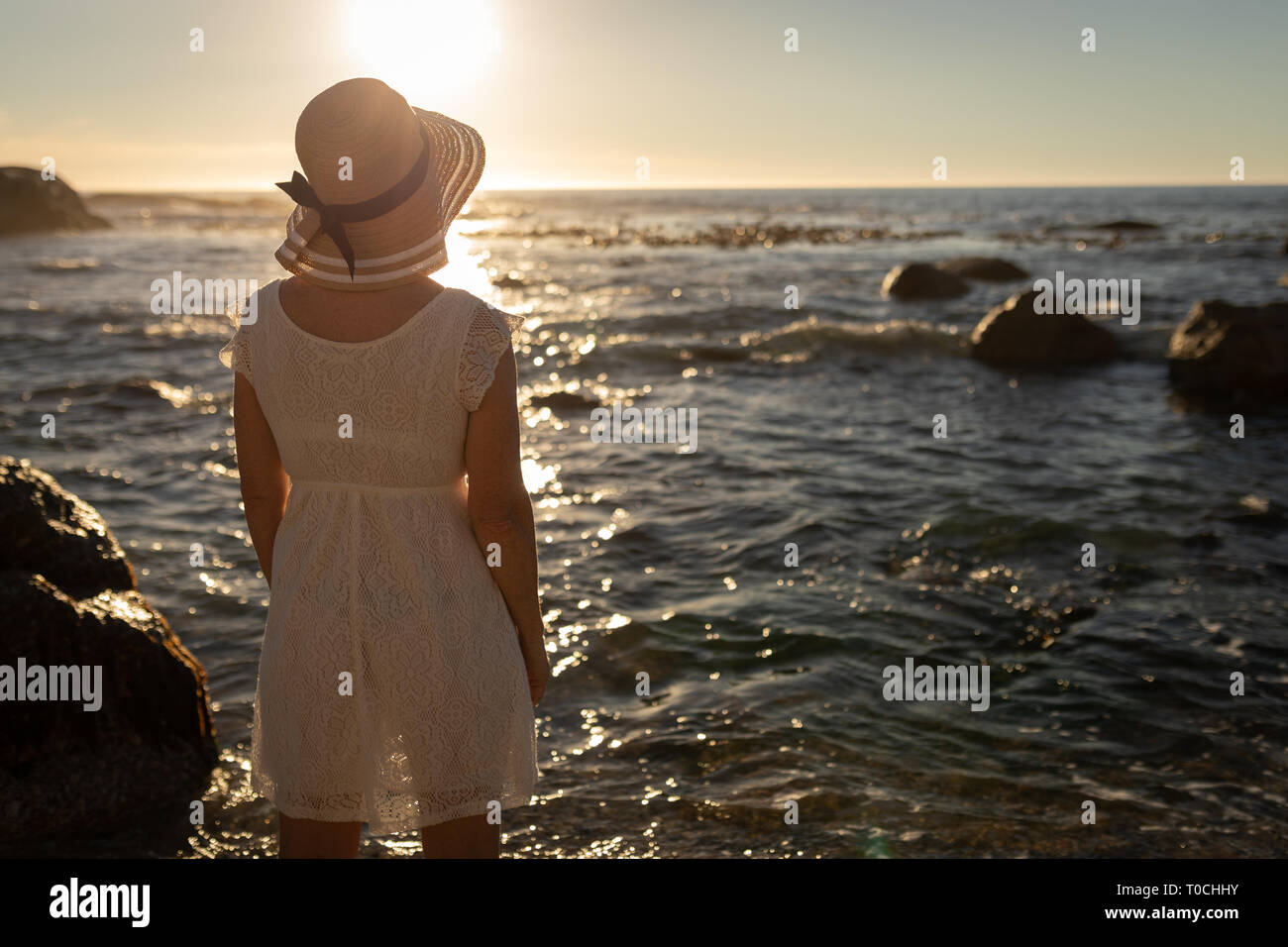 Active senior donna che guarda al mare sulla spiaggia Foto Stock