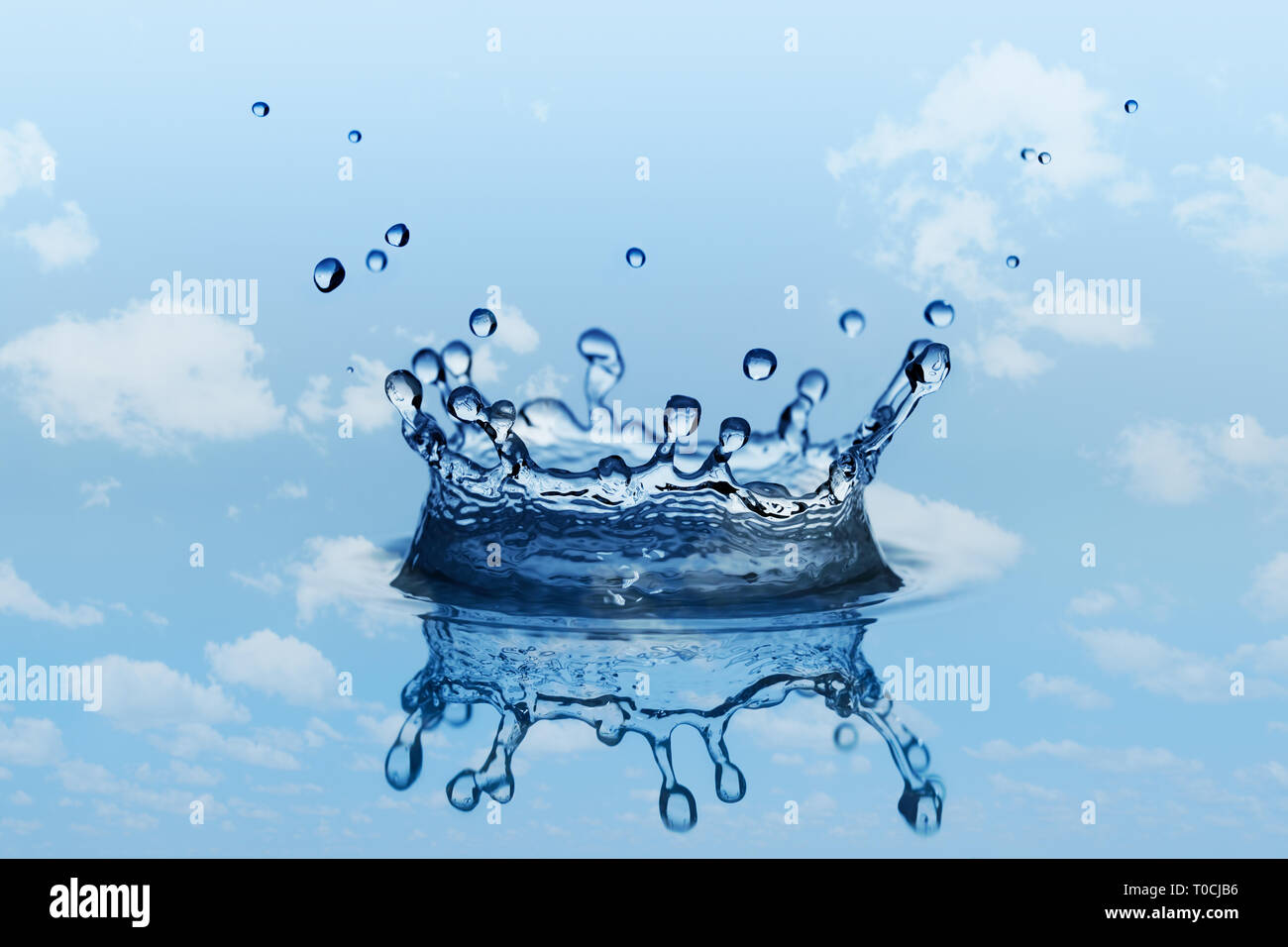 Splatter e splash in forma di corona. Piccole gocce di acqua. Il cielo blu con nuvole bianche in background. Foto Stock