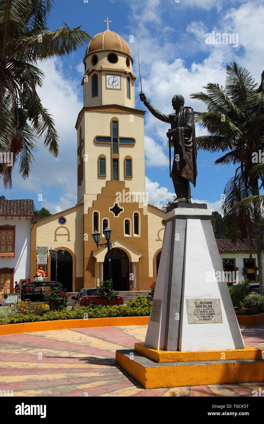 Statua di Simon Bolivar nella piazza principale del Salento in Quindío Distretto di Colombia, con la chiesa di Nuestra Señora del Carmen in background Foto Stock