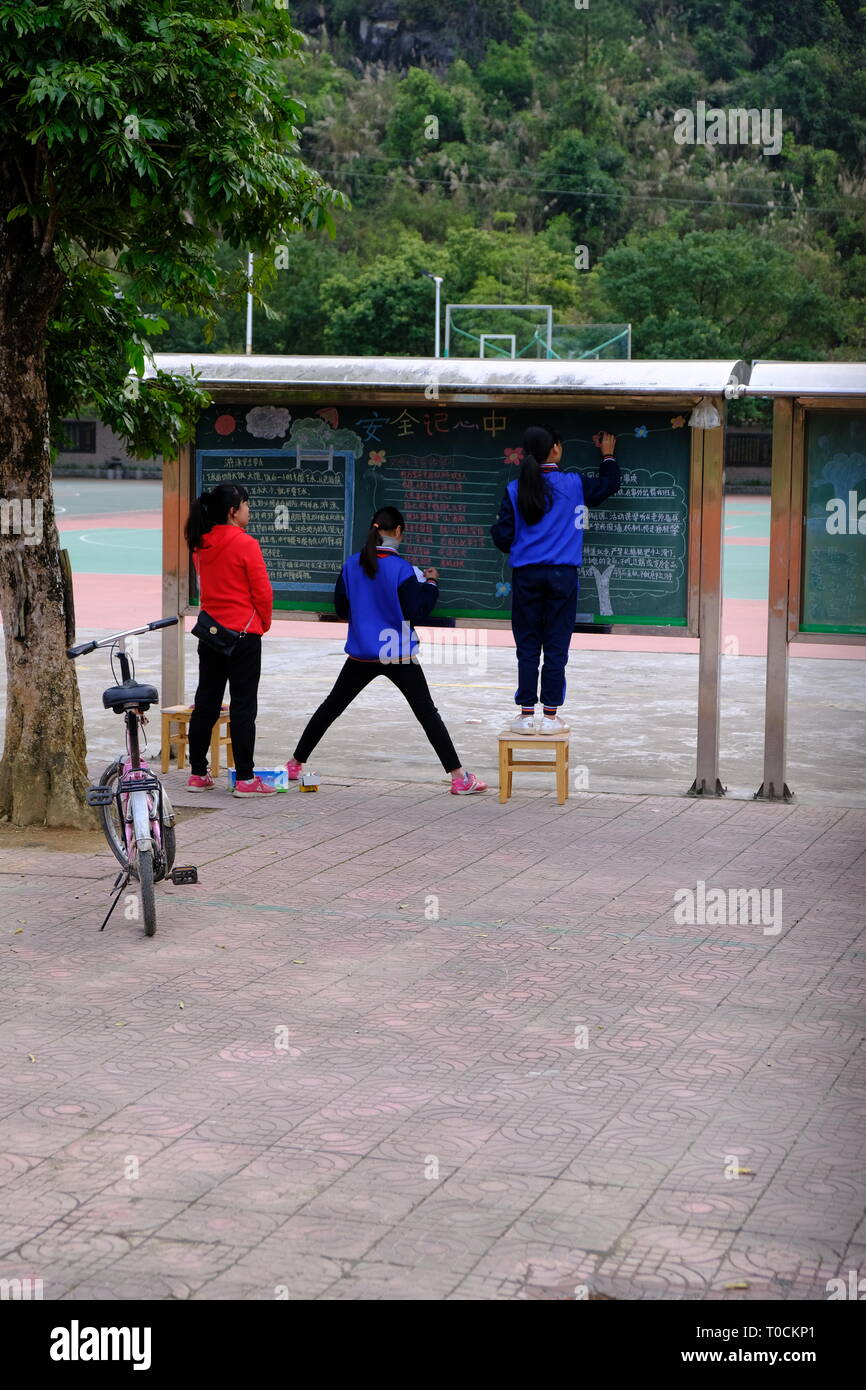 Cina studenti che lavorano sul lavoro di propaganda dopo la scuola Foto Stock