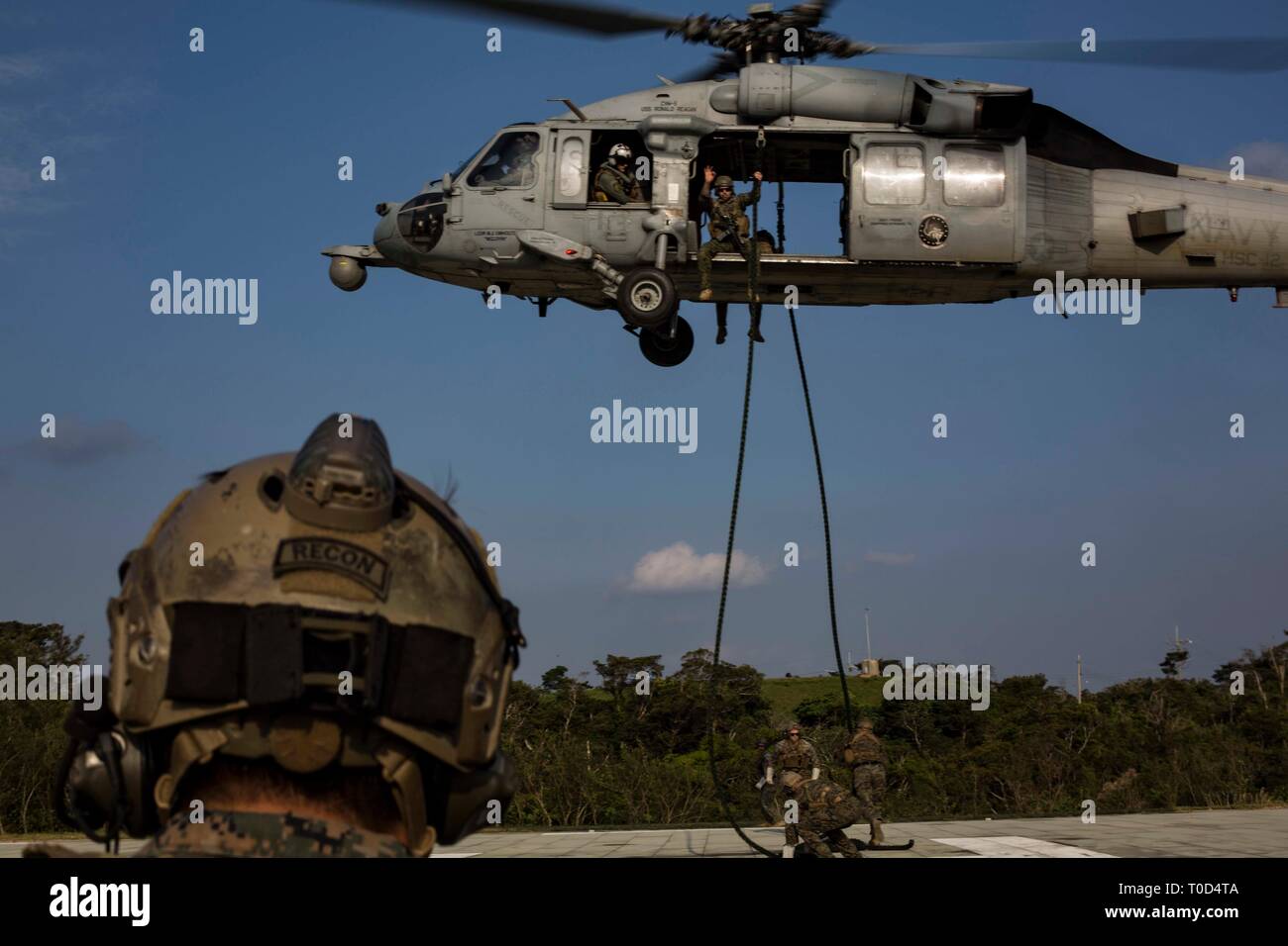 Stati Uniti Marines con 3° Battaglione di ricognizione, terza divisione Marine, condotta fast roping al di fuori di un elicottero sul Camp Hansen, Okinawa, in Giappone, Marzo 15, 2019. Durante fast roping, Marines scorrere su una fune come un mezzo di inserimento da un aeromobile in modo rapido ed efficiente. (U.S. Marine Corps Photo by Lance Cpl. Marcus Allen) Foto Stock