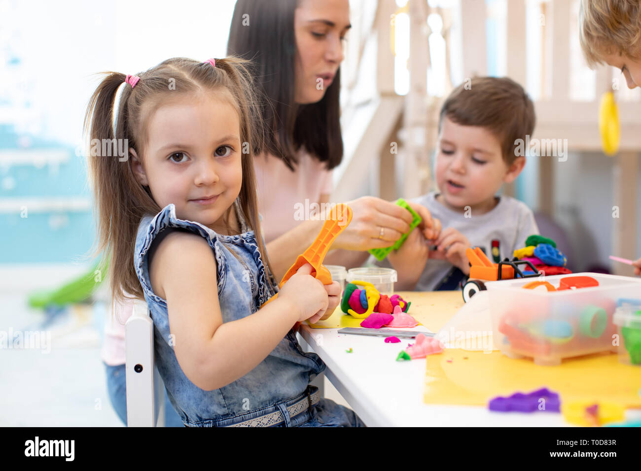 Maestra Insegna Ai Bambini Di Creta Per Modellare In Sala Giochi In Asilo Nido O Asilo Nido Foto Stock Alamy