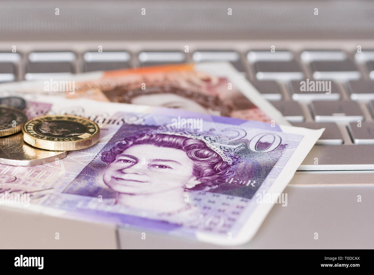 Sterlina inglese soldi su di una tastiera di notebook. Servizi di online banking e shopping online i concetti. Regno Unito Foto Stock