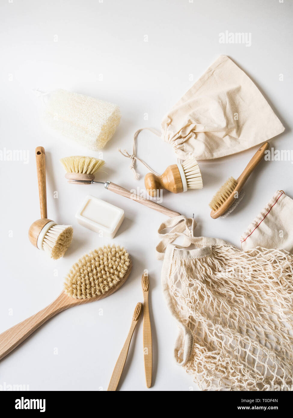 Piatto di spazzole di lavaggio, gli spazzolini da denti di bambù, sacchetti riutilizzabili su sfondo bianco. Uno stile di vita sostenibile rifiuti zero concetto. Pulizia senza residui. Nessun plasti Foto Stock