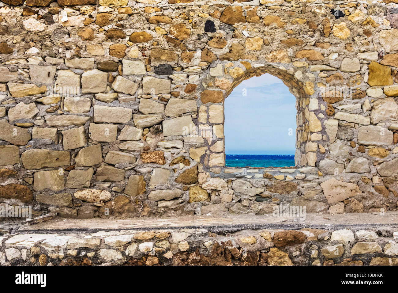 La pietra antica parete con una finestra. Vista sul mare Foto stock - Alamy