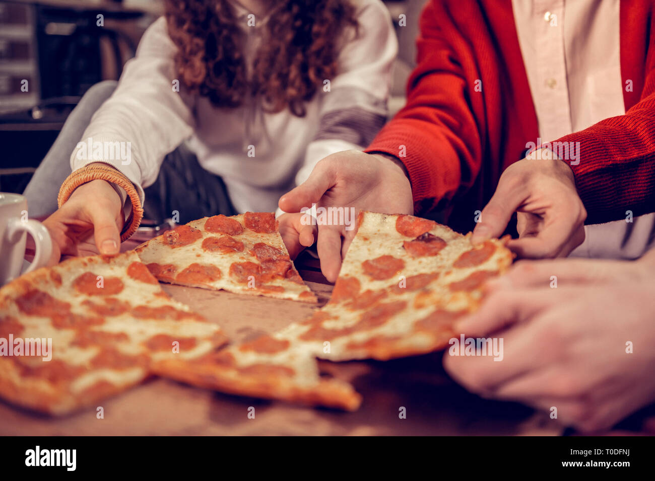 Gli studenti di musica di mangiare deliziosa pizza con salame e formaggio Foto Stock