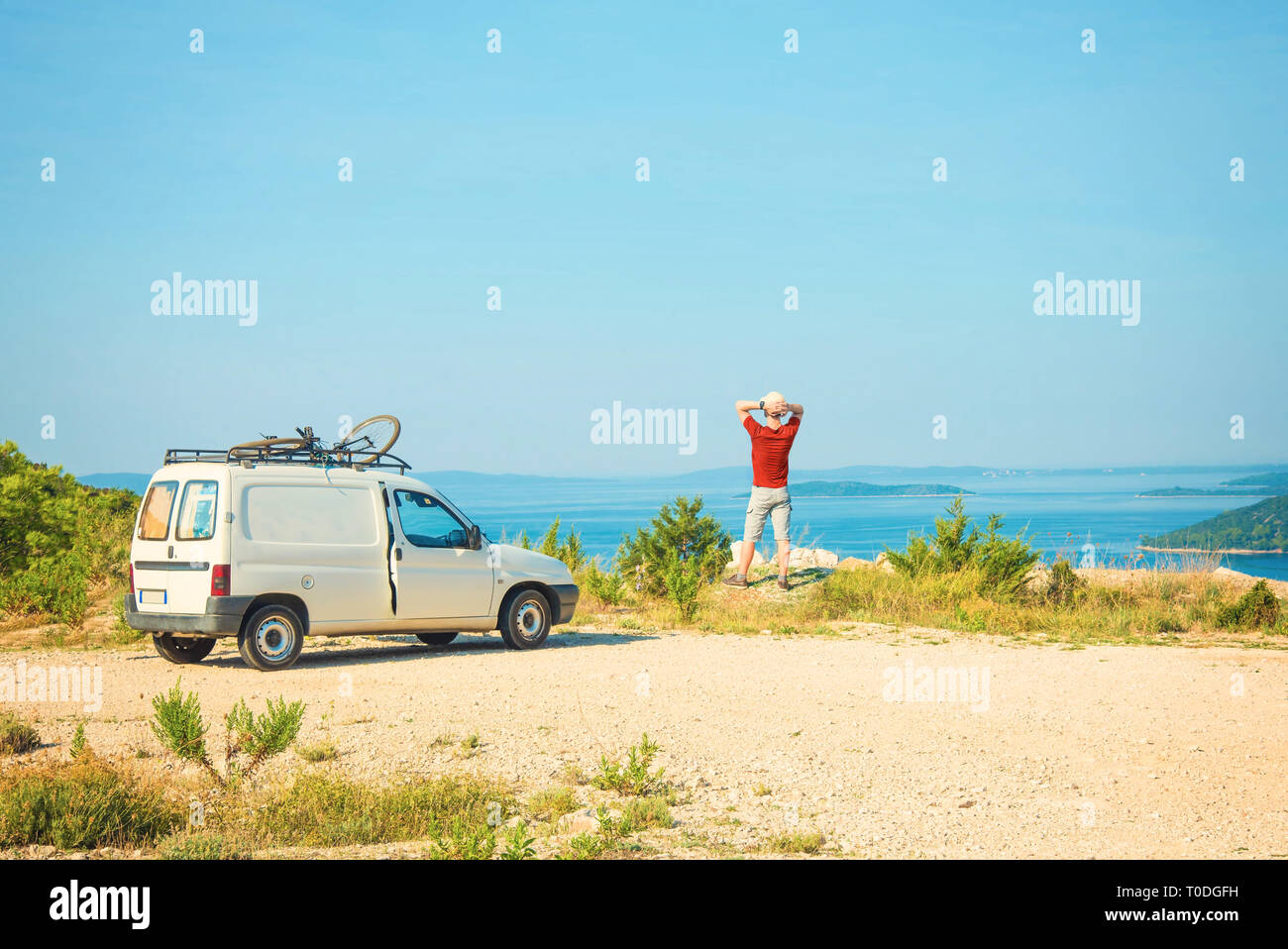 Giovane uomo caucasico gode di vista mare accanto al suo camper sulla soleggiata giornata estiva su Dugi otok in Croazia Foto Stock