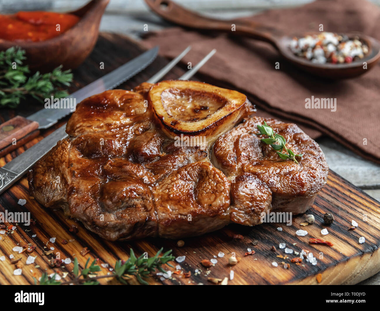 Preparati osso buco Stinco di vitello su una porzione del bordo closeup Foto Stock