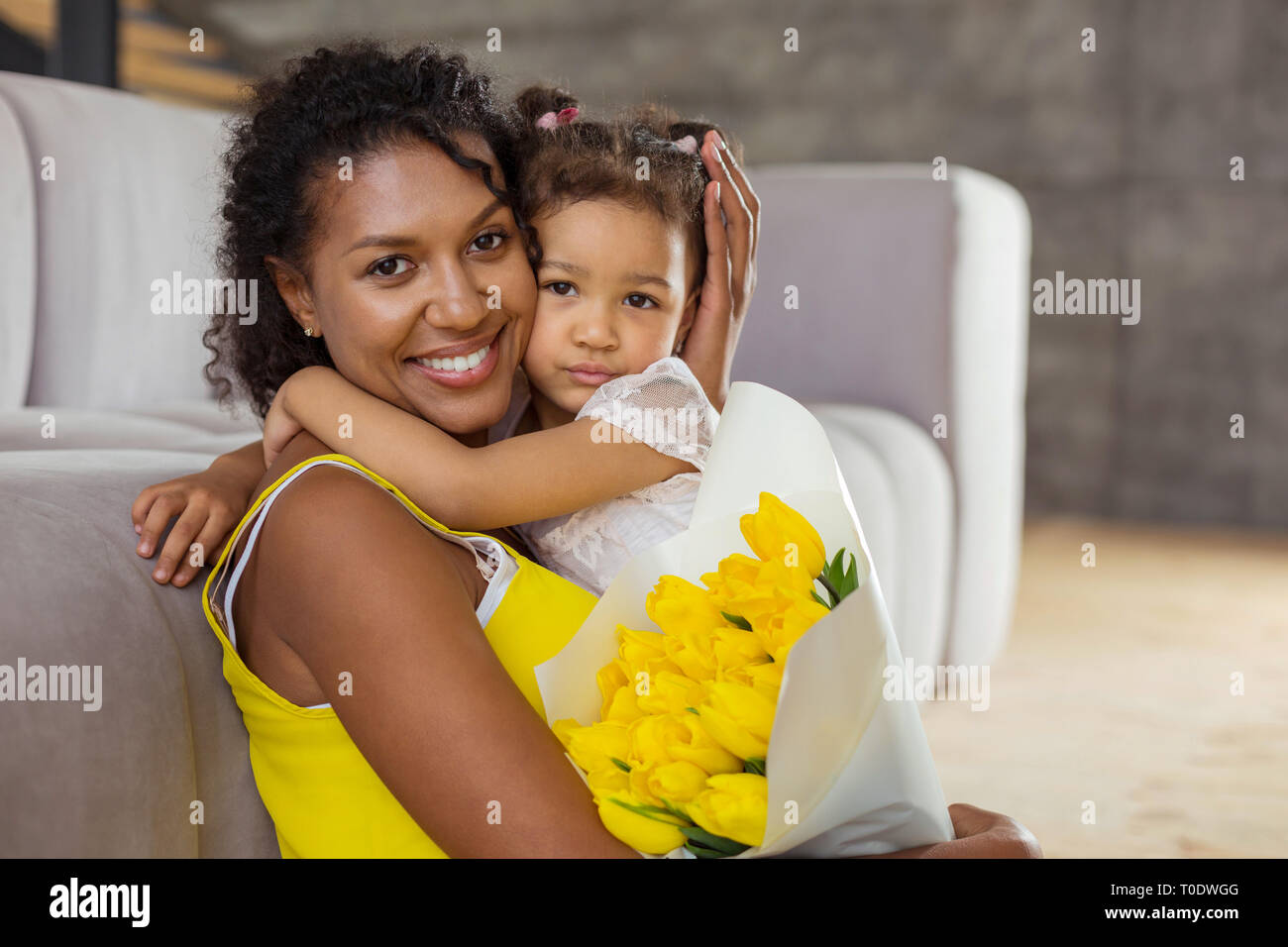 Tipo international mommy, abbracciando la figlia minore Foto Stock