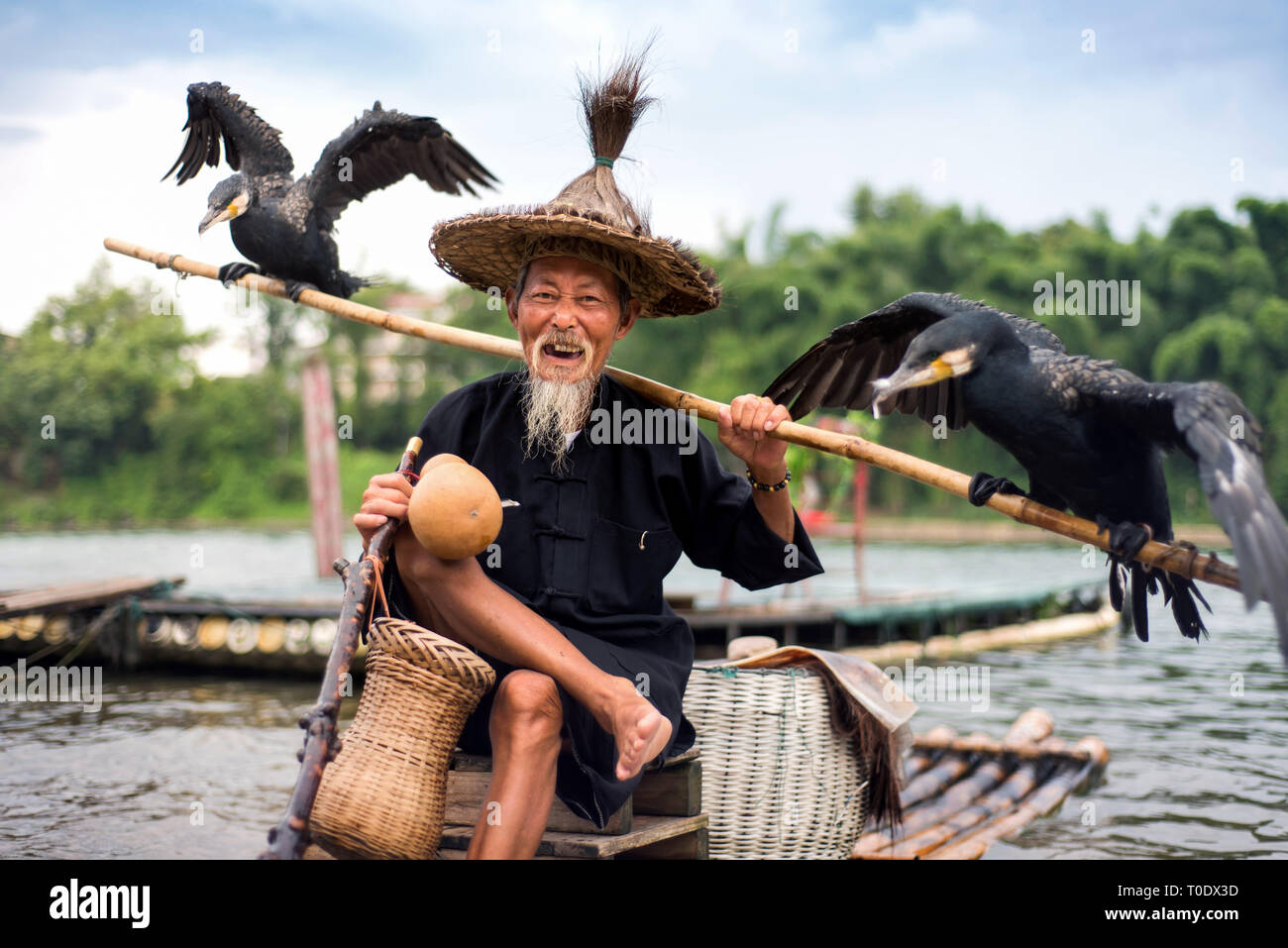 Yangshuo, Cina - 27 Luglio 2018: Tradizionale cormorano pescatore per un bambù zattere sul fiume Li in Yangshuo vicino a Guilin in Cina Foto Stock