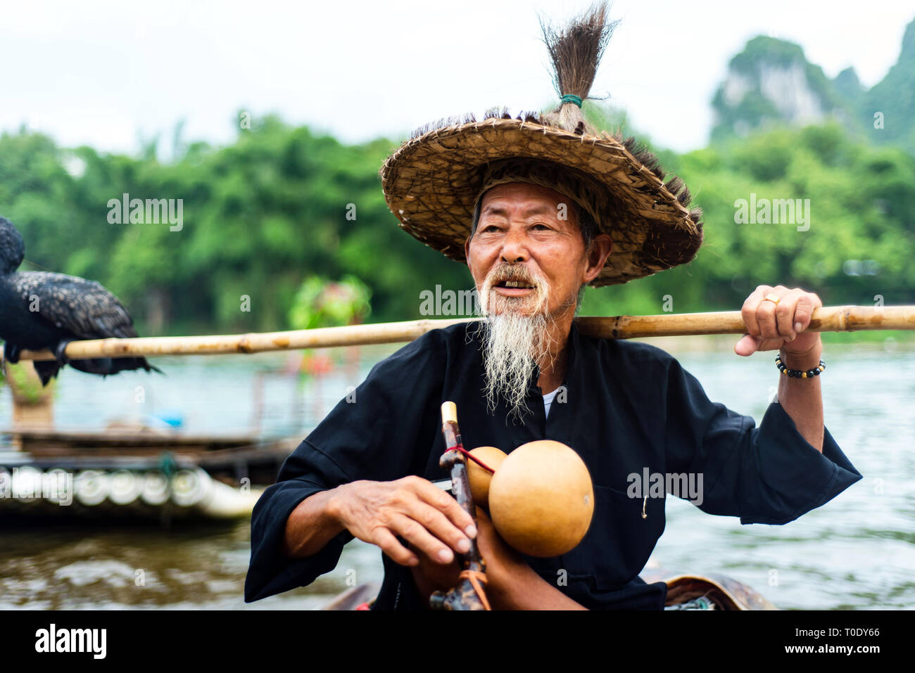 Yangshuo, Cina - 27 Luglio 2018: Tradizionale cormorano pescatore per un bambù zattere sul fiume Li in Yangshuo vicino a Guilin in Cina Foto Stock