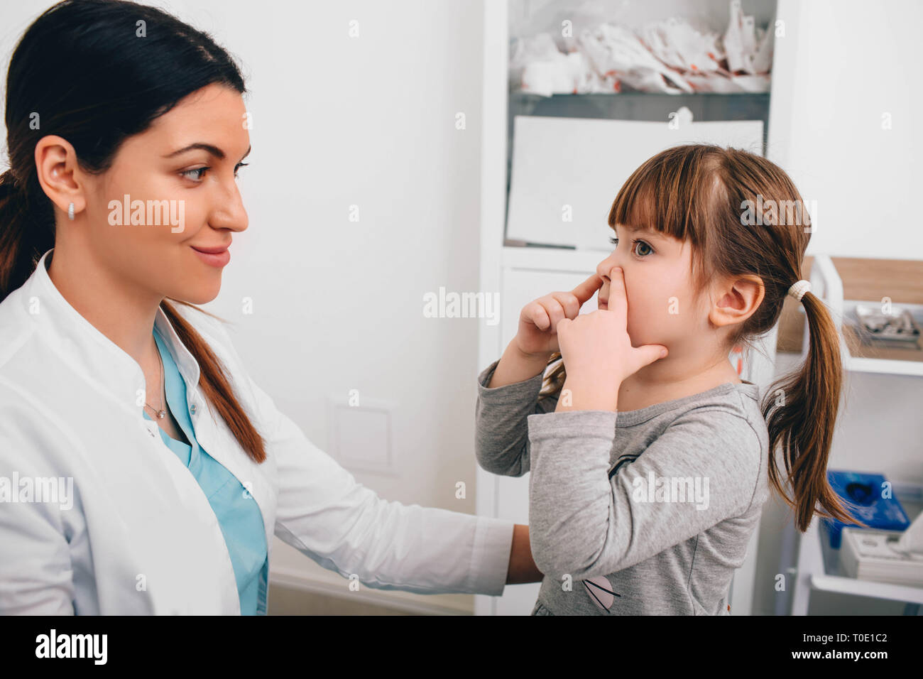 Piccolo paziente che descrive il suo problema di respirazione al pediatra Foto Stock