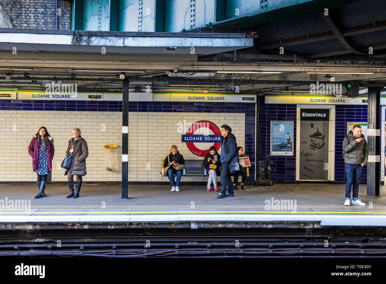 Persone sulla piattaforma hte in attesa di un treno sotterraneo alla stazione della metropolitana di Sloane Square, Londra, Regno Unito Foto Stock