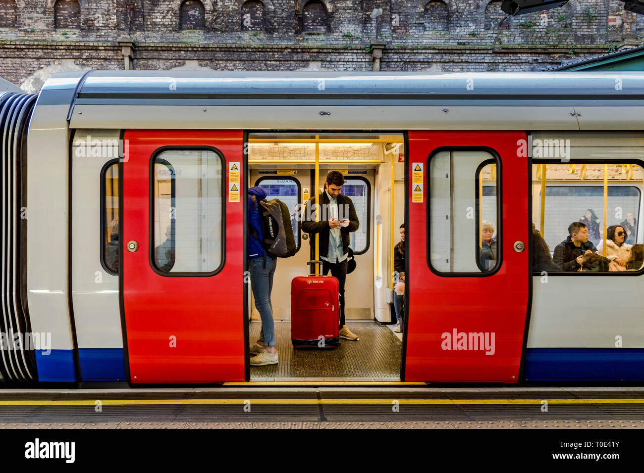 Persone su un treno District Line/Circle Line in attesa che le porte siano chiuse alla stazione della metropolitana di Sloane Square, Londra, Regno Unito Foto Stock