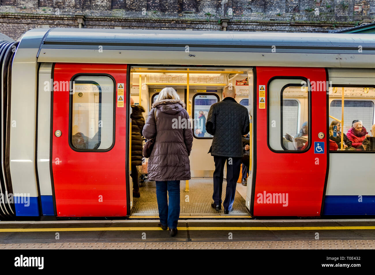 Persone a bordo di un treno District Line alla stazione della metropolitana di Sloane Square, Londra, Regno Unito Foto Stock