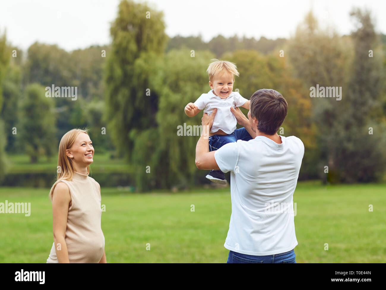 La famiglia felice che giocano nel parco. Foto Stock