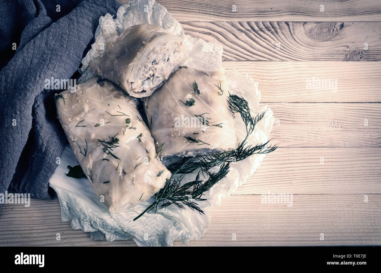 Farcite involtini di cavolo ripiene di carne e riso con verdure in foglie di cavolo su un vecchio tavolo di legno. Foto Stock