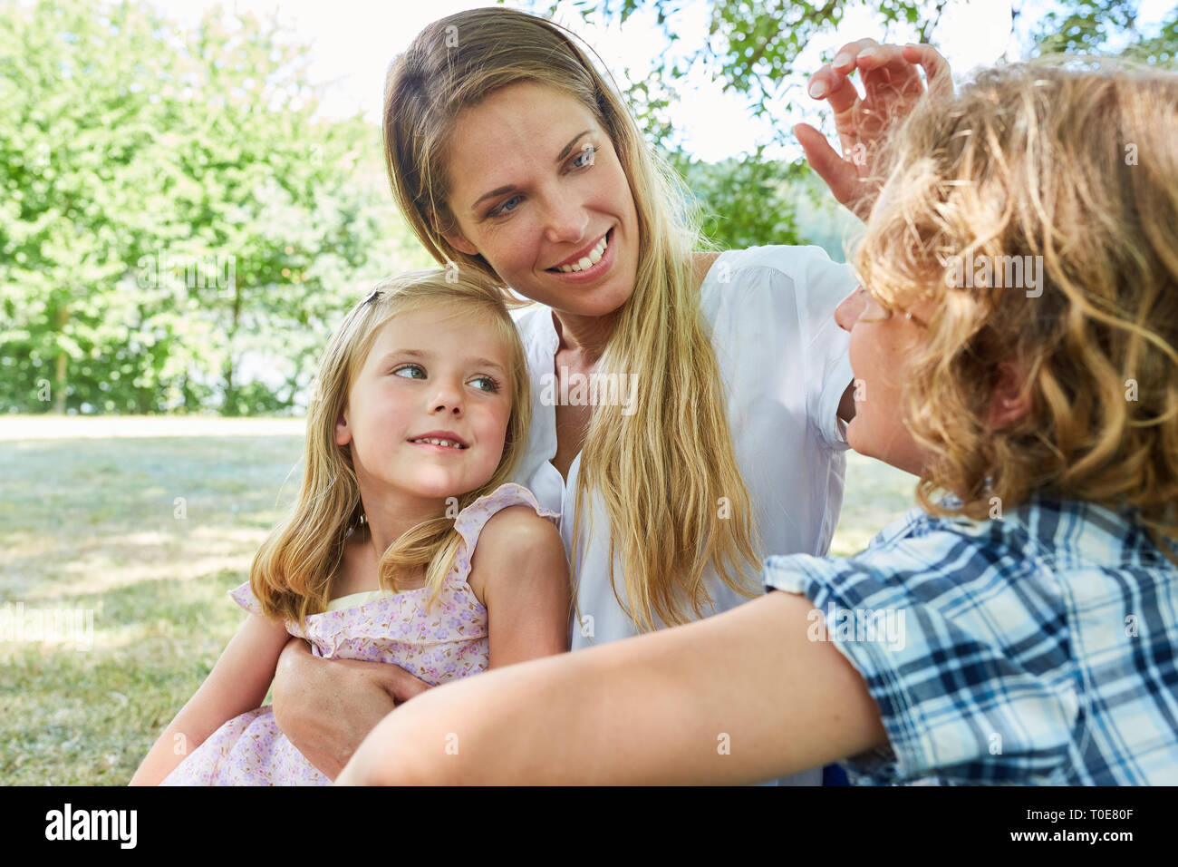 Donna felice come una madre single con due bambini in estate nel parco Foto Stock