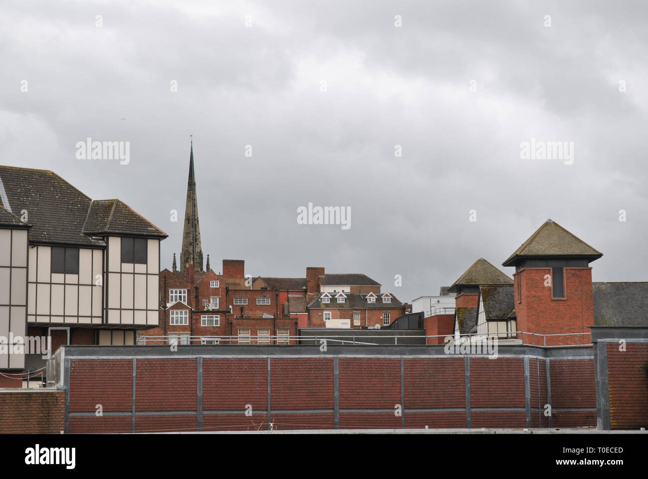 Lo Skyline di Shrewsbury mostra sui tetti dei due centri per lo shopping e la guglia di una chiesa in background Foto Stock