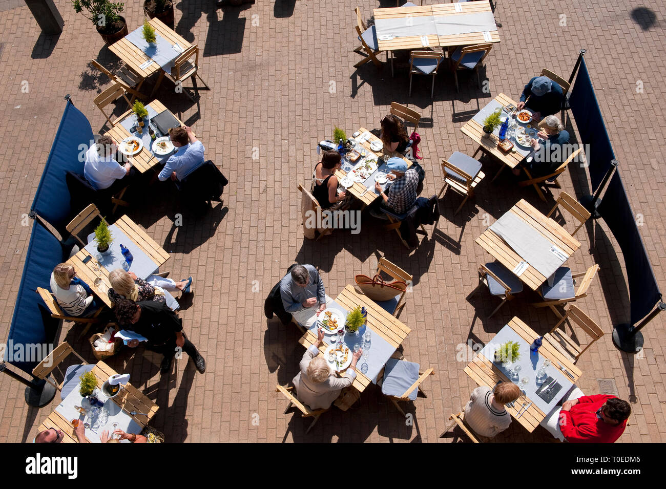 La gente seduta al di fuori del caffè lungo la passeggiata sul lungomare di Brighton, Sussex, Inghilterra. Foto Stock