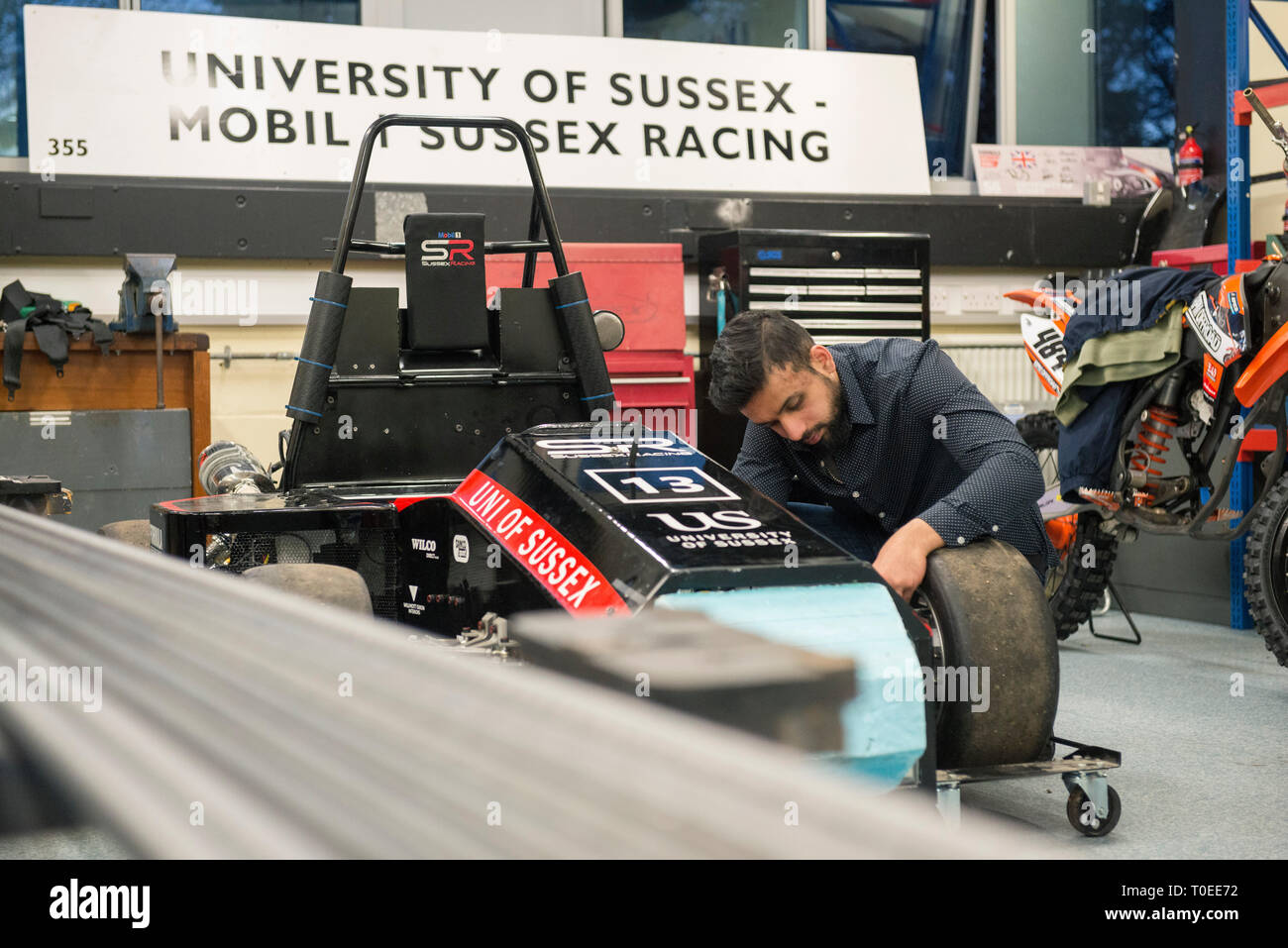 Un giovane musulmano internazionale studente woking su un racing motorsport carrello nel dipartimento di ingegneria meccanica dell'Università del Sussex Foto Stock