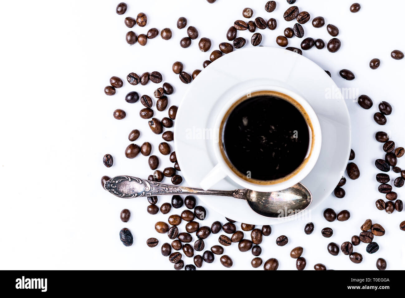 Porcellana Bianca tazza di caffè con caffè torrefatto in grani isolati su sfondo bianco vista superiore Foto Stock