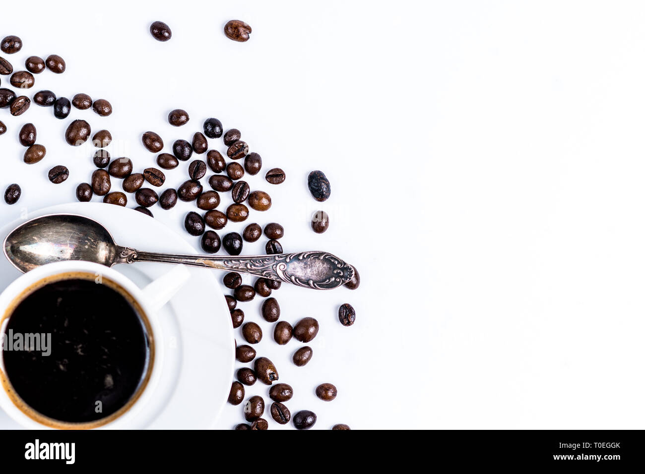 Porcellana Bianca tazza di caffè con caffè torrefatto in grani isolati su sfondo bianco vista superiore Foto Stock