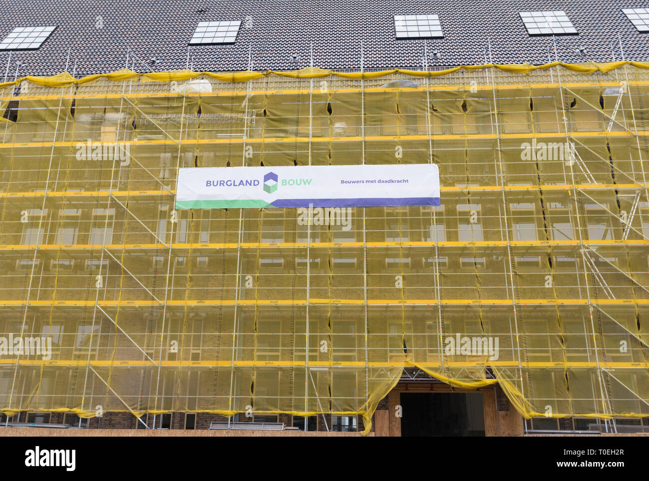 Ristrutturazione di un edificio di appartamenti in centro città con i ponteggi e reti di sicurezza in Utrecht, Paesi Bassi Foto Stock