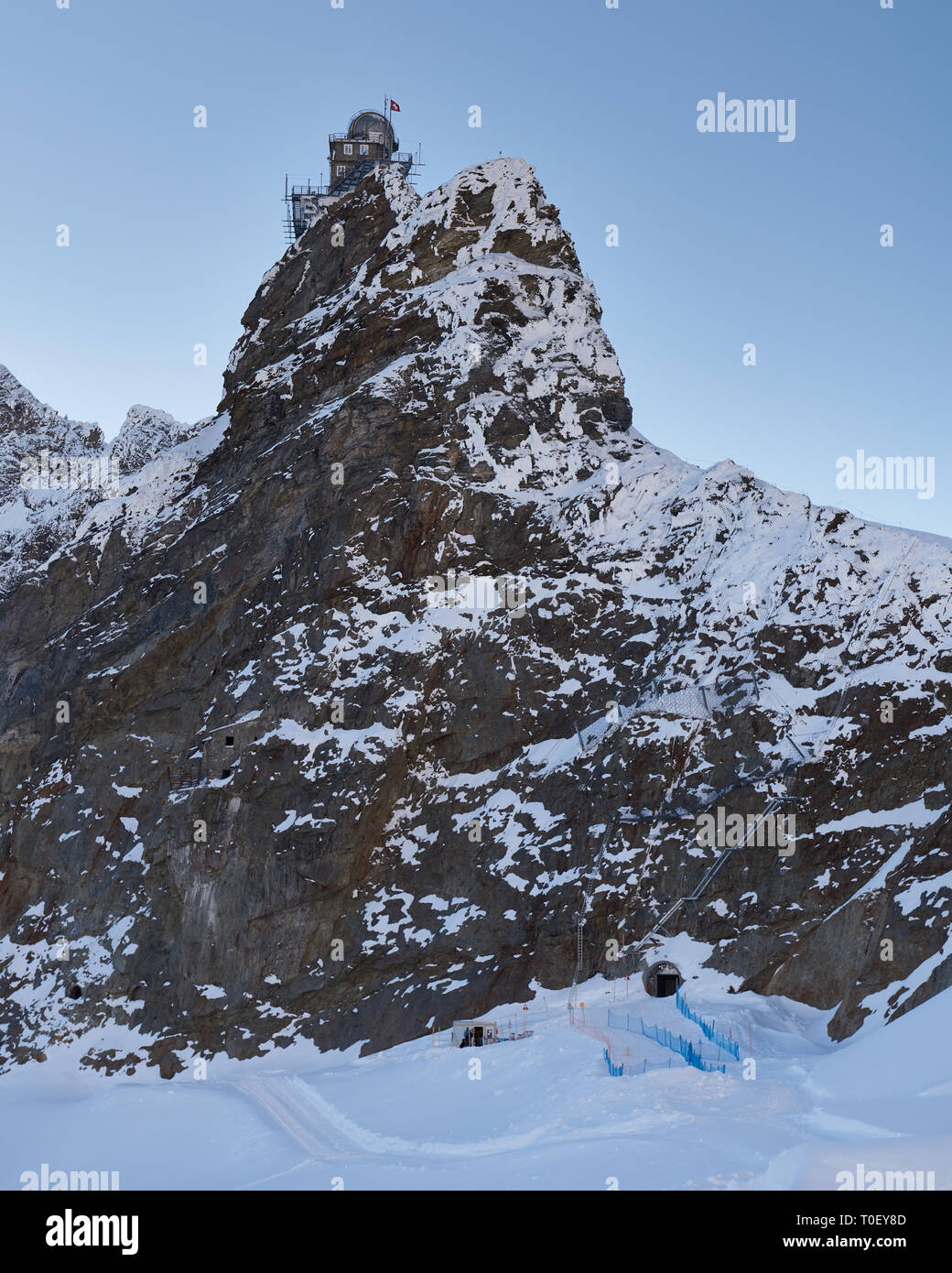 Scollegato nella regione della Jungfrau. Una vista del tramonto di elevata altitudine osservatorio Sphinx visto da un lato ovest sentiero di neve Foto Stock