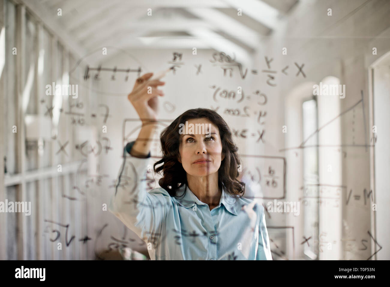 Mathmetician lavorando per risolvere l'equazione. Foto Stock