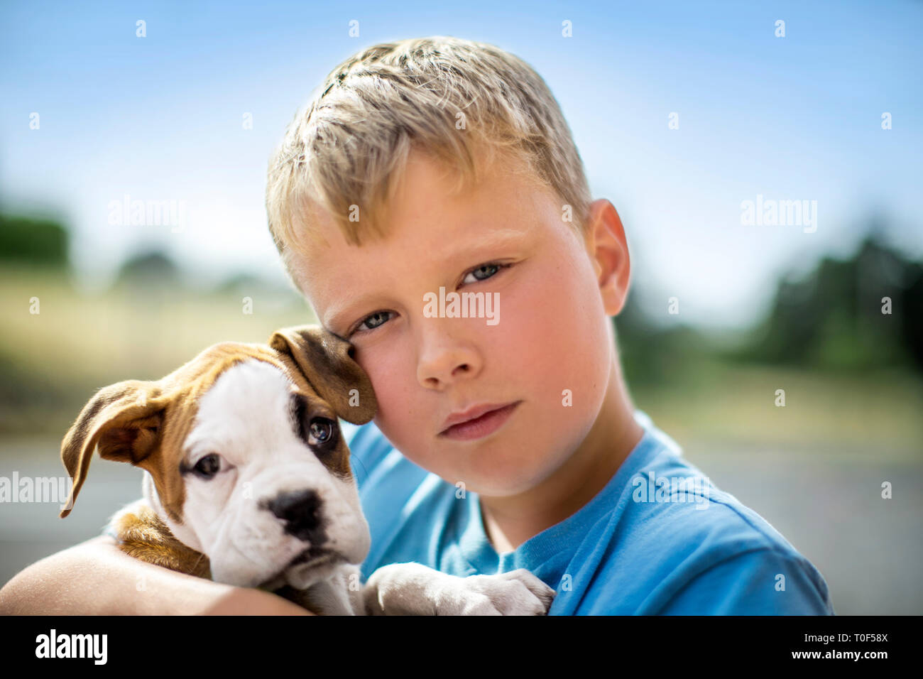 Ritratto di un giovane ragazzo tenendo la sua bulldog cucciolo. Foto Stock