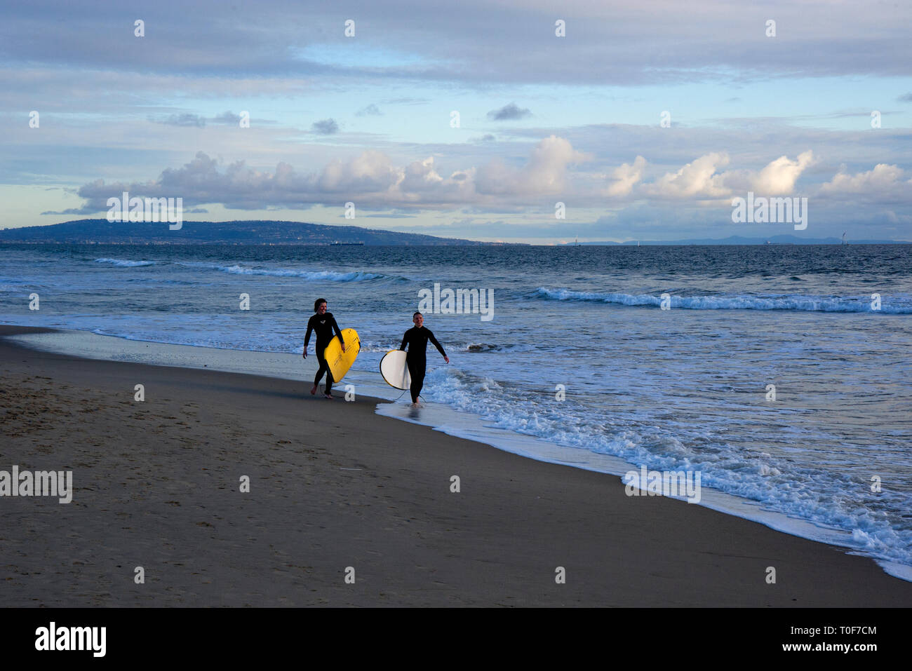 Surfisti a Santa Monica Beach con Palos Verdes peninsula in background Foto Stock