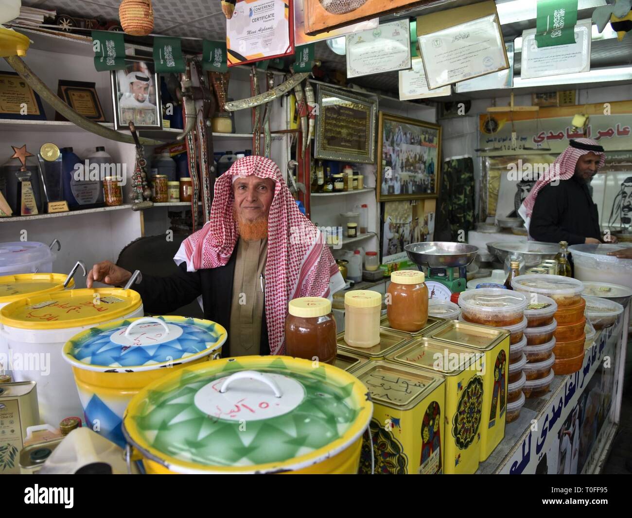 Abha, Arabia Saudita. Xix Mar, 2019. Un commerciante di miele è visto al mercato Thulatha di Abha, Provincia di Asir, Arabia Saudita, il 19 marzo 2019. Thulatha, un famoso mercato tradizionale nella città di Abha, vende prodotti freschi e artigianato locale come il miele, date, oro e argento gioielli beduini, donna abiti ricamati e localmente-realizzato pugnali. Il mercato Thulatha utilizzato per operare solo il martedì, e ora è aperta sette giorni alla settimana, attraendo un sacco di acquirenti e visitatori. Credito: Tu Yifan/Xinhua/Alamy Live News Foto Stock