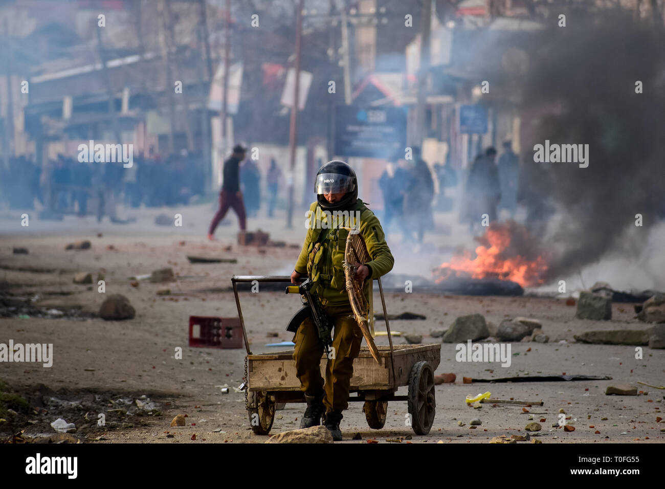 Un indiano funzionario di polizia si vede la rimozione di barriera durante gli scontri. Intensi scontri scoppiati in Awantipora area del Kashmir sud del distretto di Pulwama in mezzo a un arresto spontaneo a seguito della pena di morte in una scuola locale insegnante Rizwan Pandit. Pandit, che è stato arrestato dalla polizia in una militanza-caso correlato, è morto in custodia della polizia alla FFS Cargo camp in Srinagar la notte scorsa, la polizia ha detto. Foto Stock