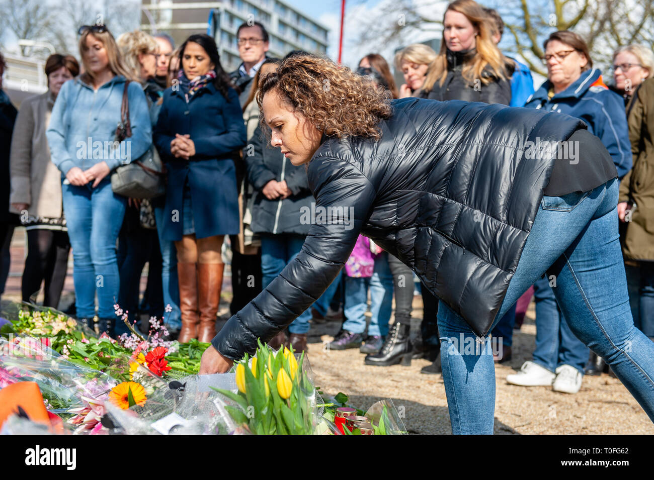 Una donna è visto la posa di un mazzo di fiori presso il memoriale. Il giorno dopo le tre persone sono state uccise e cinque feriti durante una sparatoria su un tram nella città olandese di Utrecht, centinaia di persone sono state mettendo i fiori e lettere di consolazione durante tutta la giornata, al Oktoberplein il luogo dove dalla fermata del tram e un uomo ha cominciato a sparare. Foto Stock