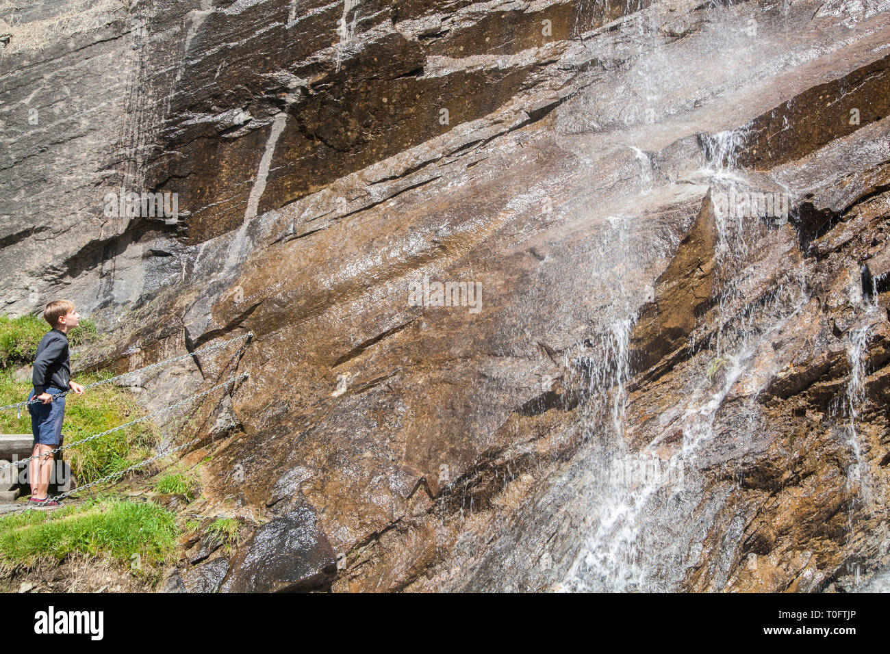 Un ragazzo a guardare la cascata nel Parco Nazionale degli Alti Tauri in Austria Foto Stock