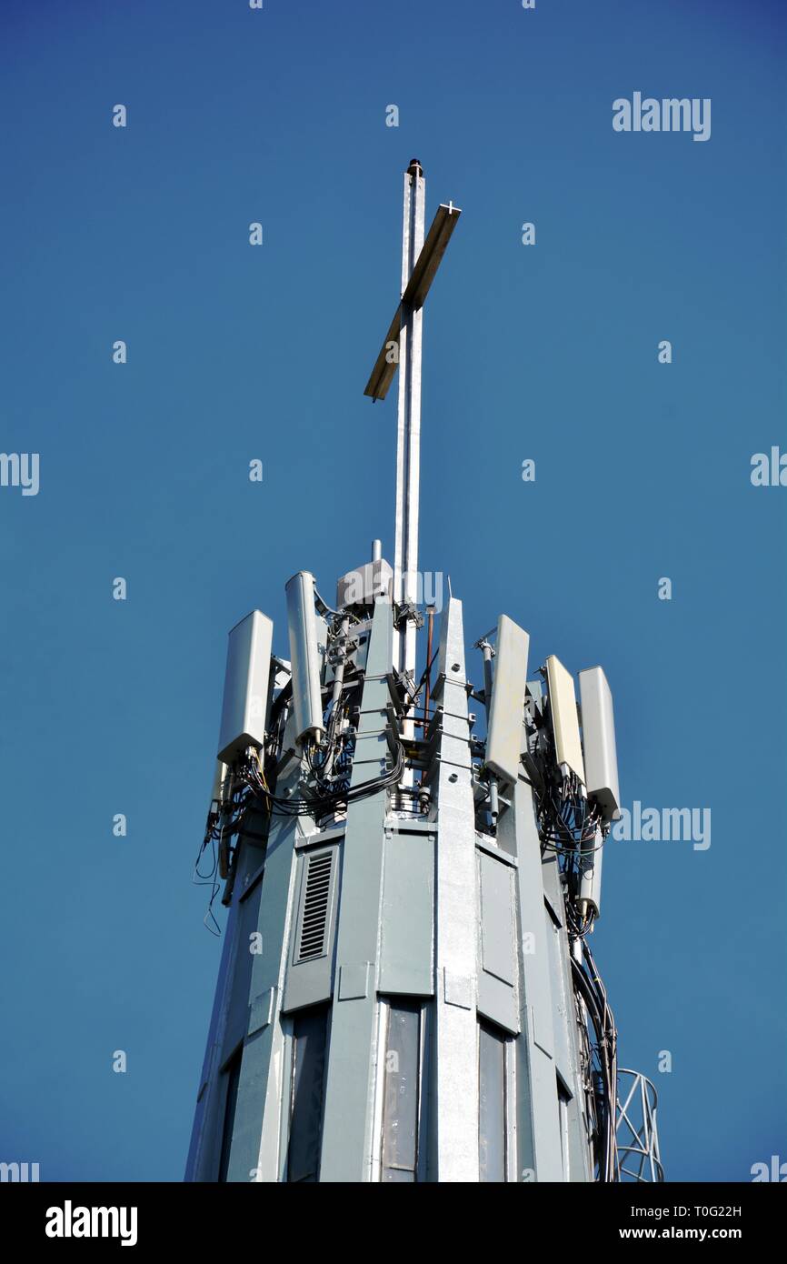 Campanile di una chiesa con una croce e ricevitori Foto Stock