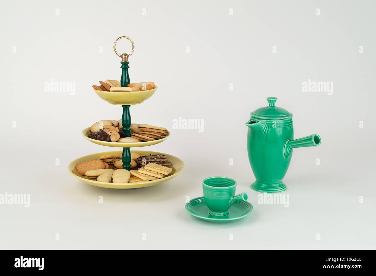 Tre Tier Mid-Century moderno piatto di portata con vetri giallo piastre in bachelite verde stelo anello di ottone maniglia per dessert tè pentola caraffa di caffè Foto Stock