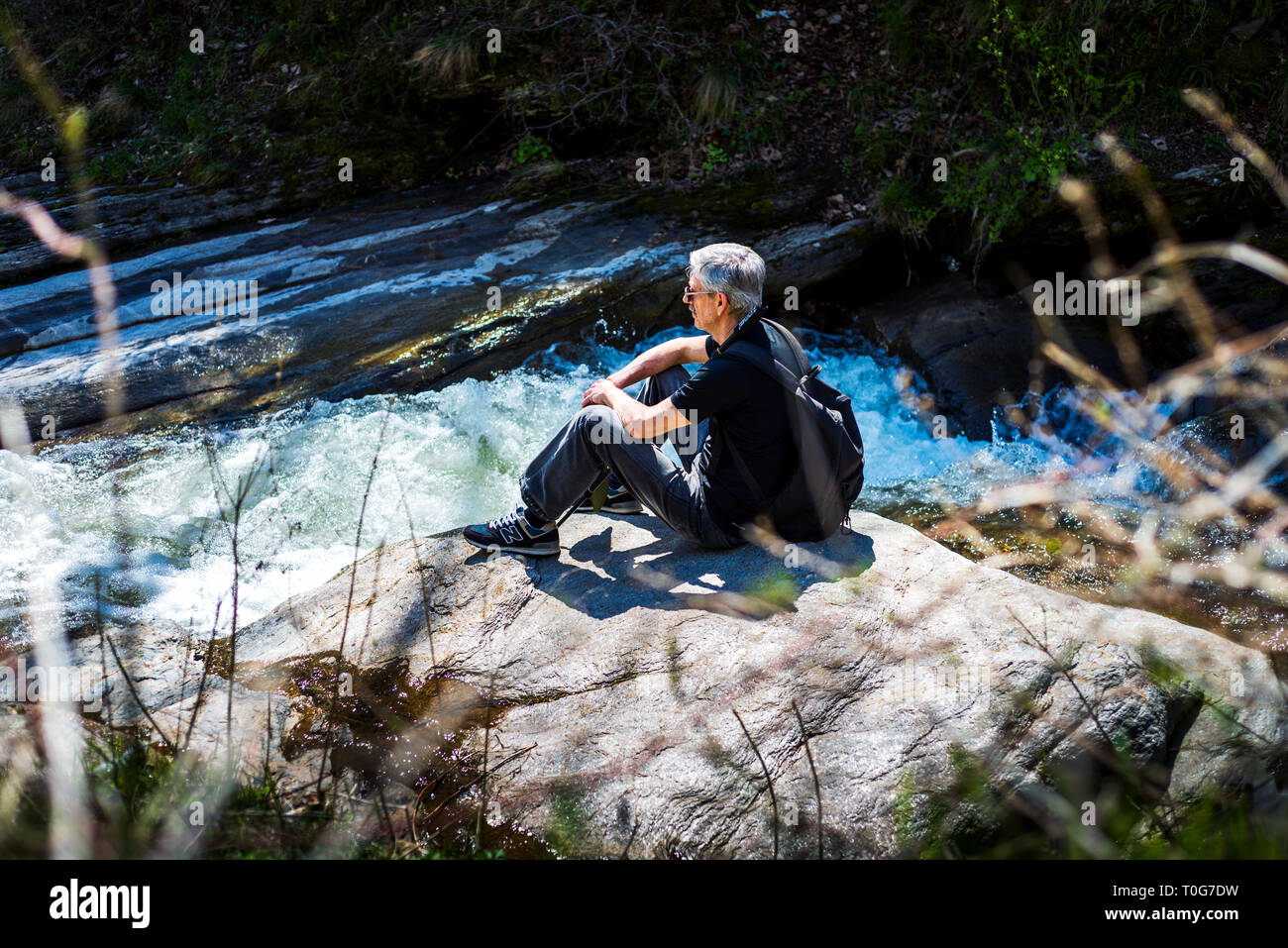 Senior uomo su una escursione lungo il fiume da soli Foto Stock