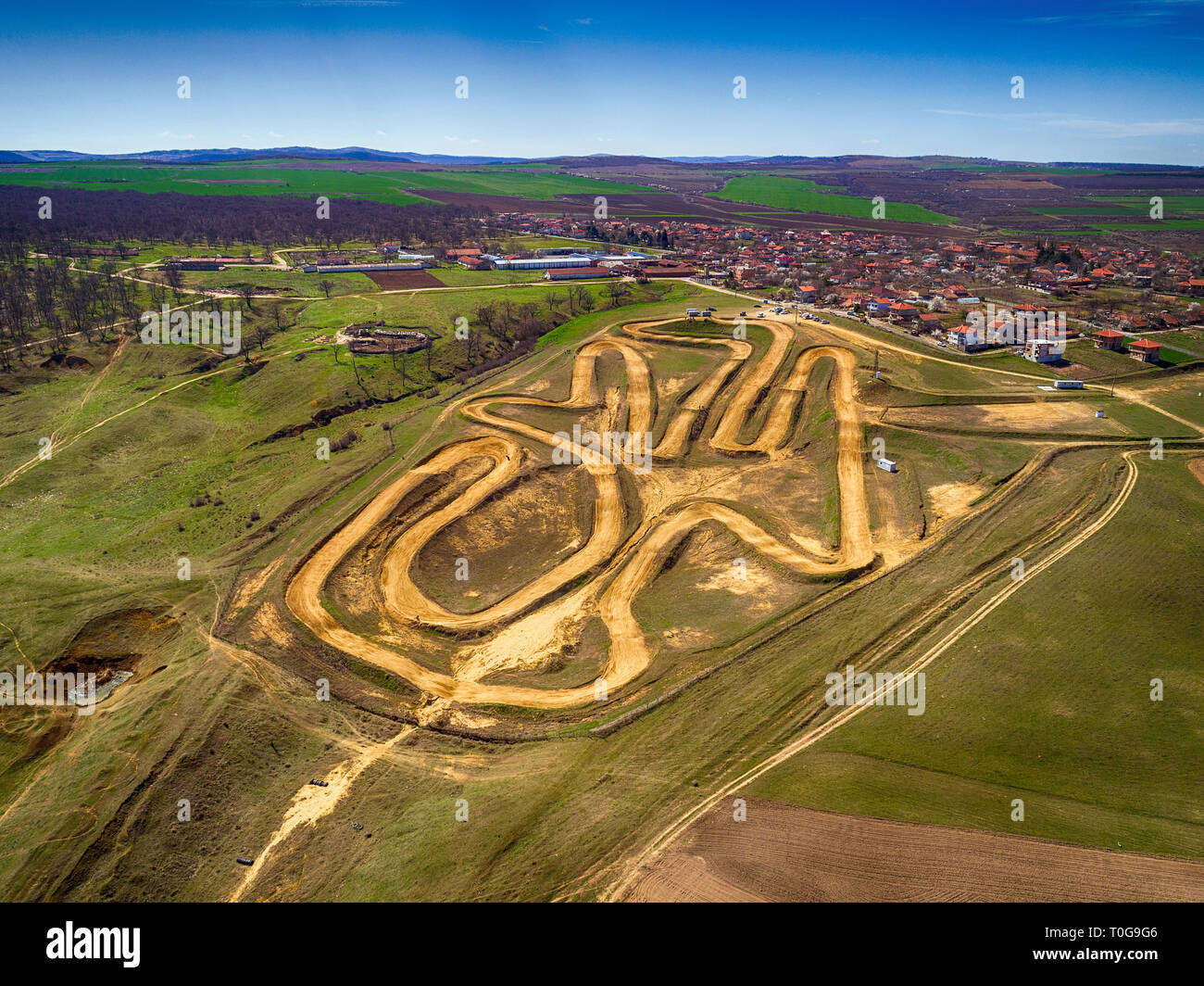 Antenna top down foto della pista di motocross che mostra le alte prestazioni off-road moto racing su disegni manmade circuito sterrato con salto ripido Foto Stock