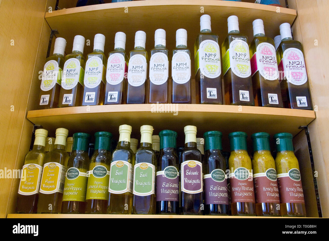 Varie bottiglie di condimento sul display e per la vendita in uno specialista deli shop. Foto Stock