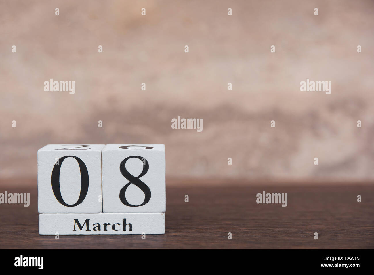 Donna con il giorno 8 marzo il calendario blocco di legno cubo con numero sul tavolo listone scuro dello sfondo di legno con spazio di copia Foto Stock