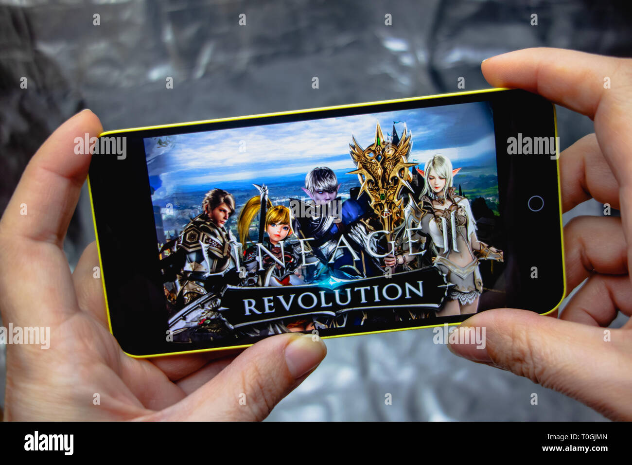 Berdyansk, Ucraina - 16 Marzo 2019: mani di uno smartphone con lineage 2 revolution gioco sullo schermo di visualizzazione. Foto Stock