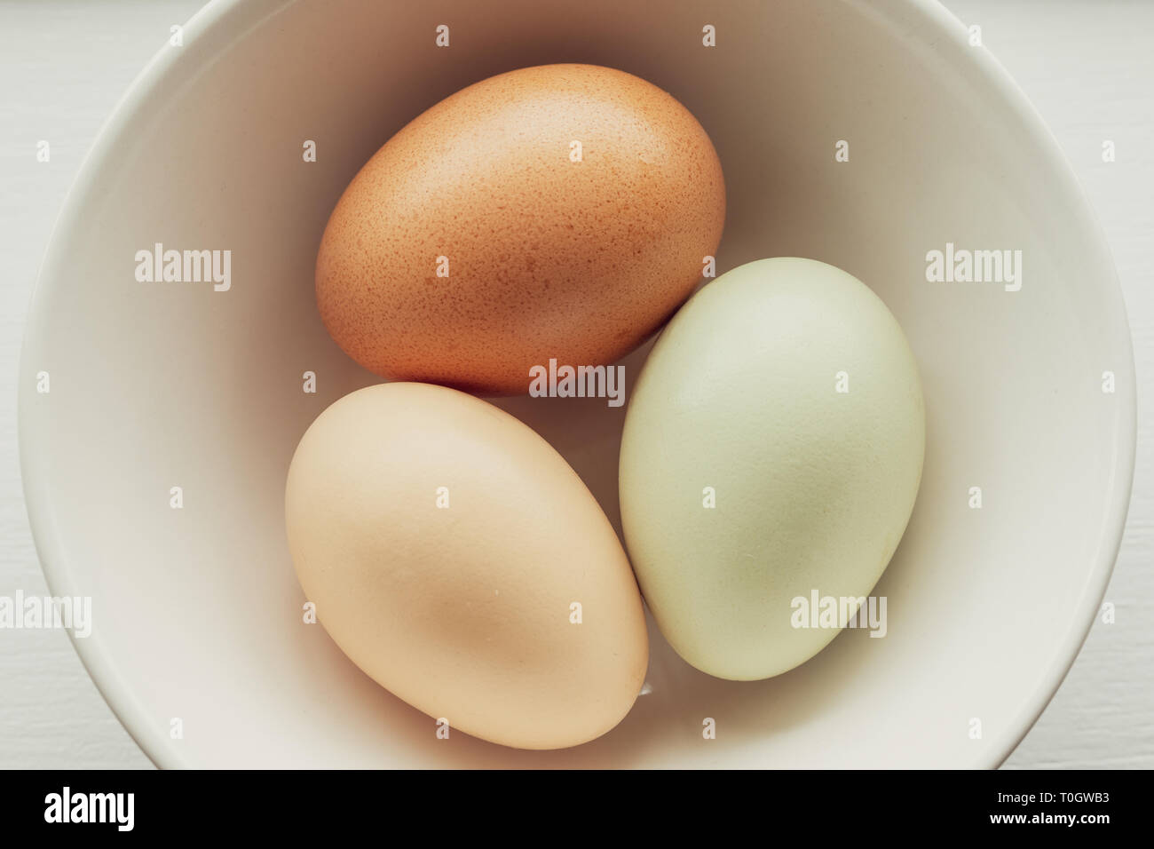 Tre Colorate, fresche uova di fattoria nel recipiente Foto Stock