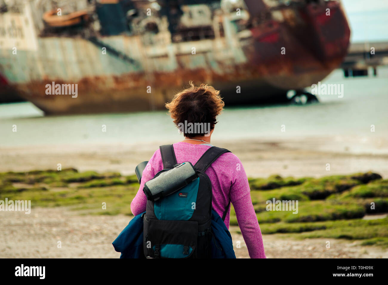 Fotografo donna nella spiaggia di scattare foto a una barca Foto Stock