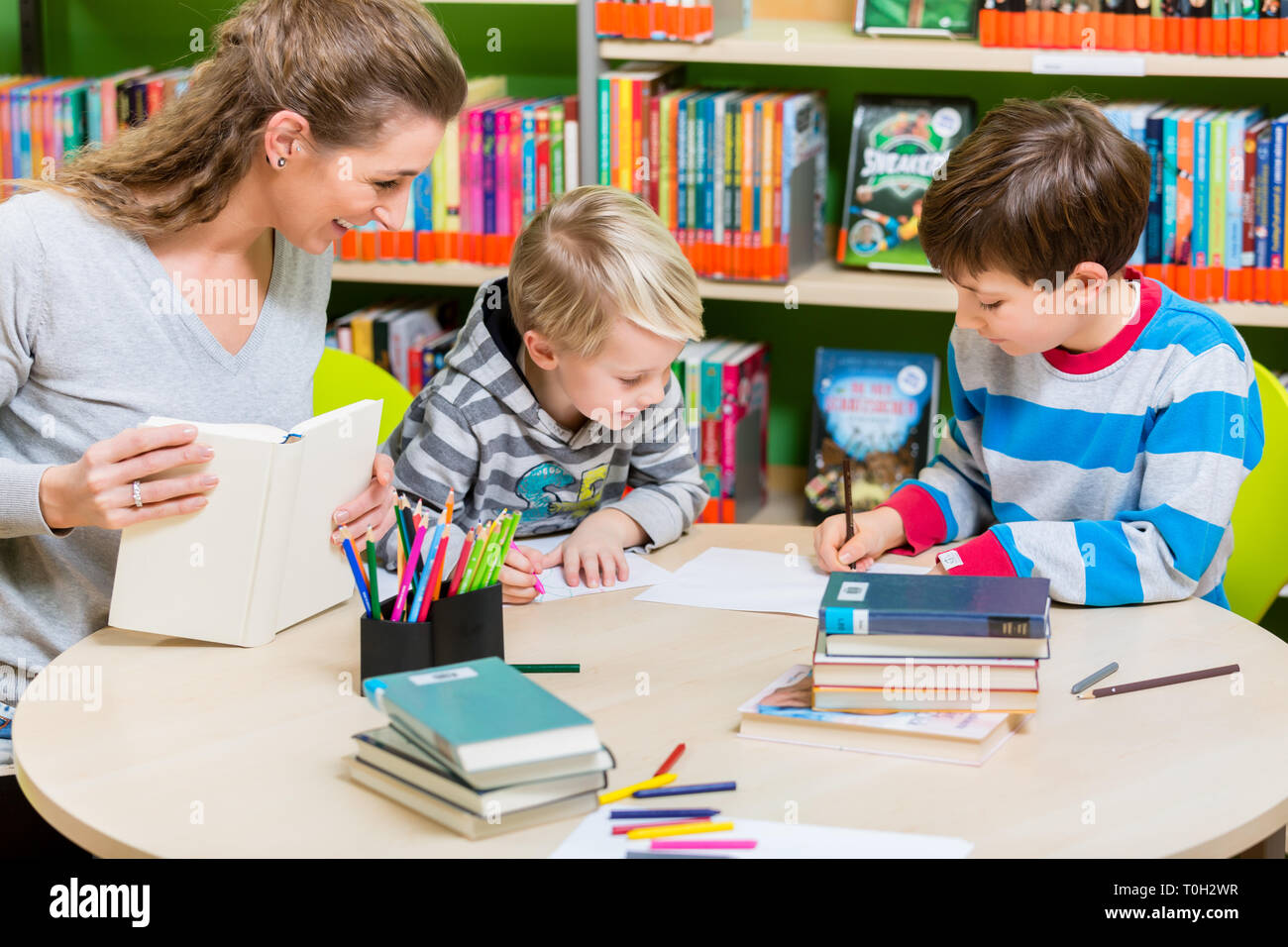 Madre libro dalla biblioteca per suo figlio Foto Stock