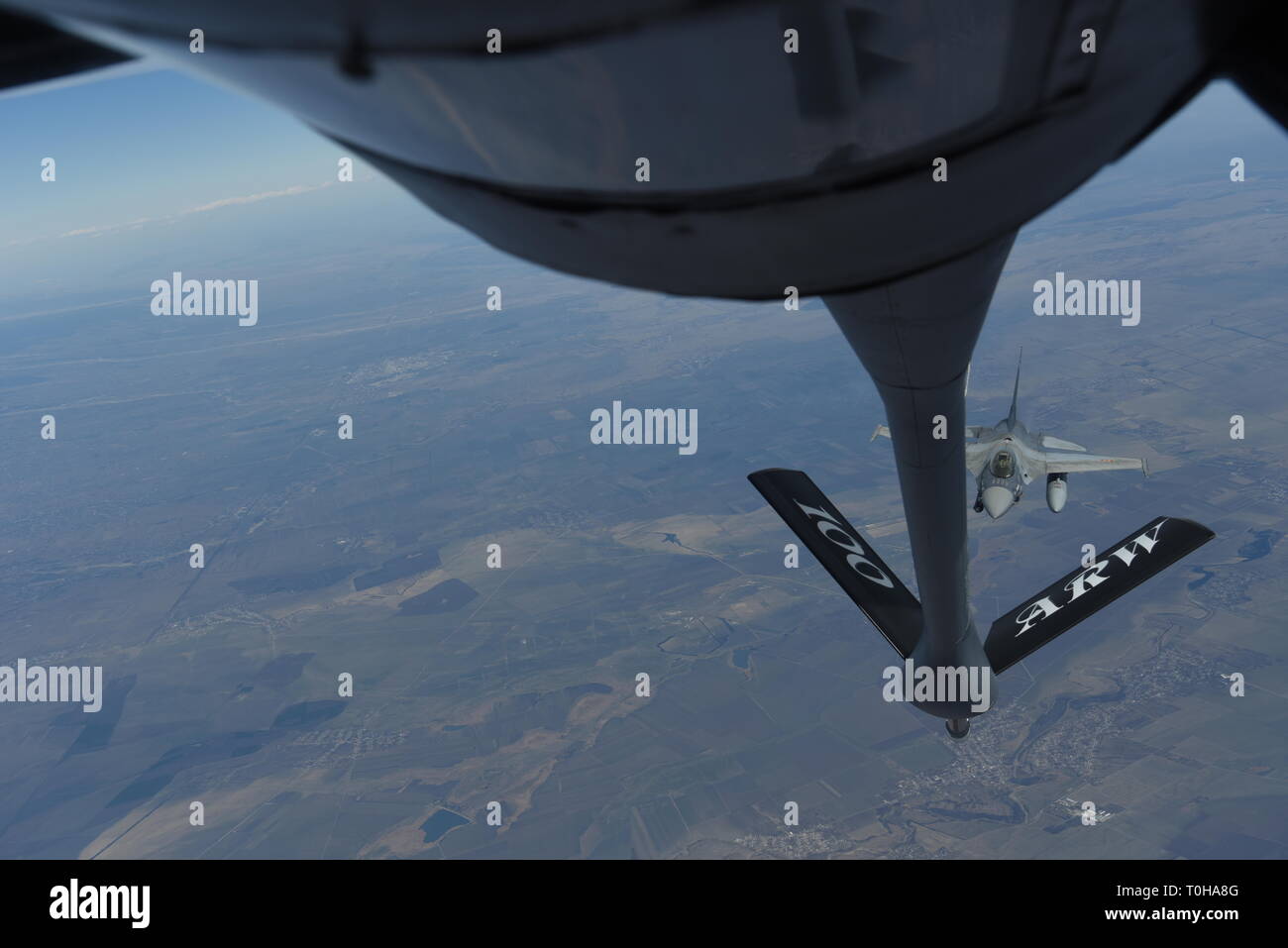 Un rumeno air force F-16 si prepara a ricevere carburante da un KC-135 Stratotanker da RAF Mildenhall, Inghilterra durante il corso di formazione oltre i cieli di Romania, 11 marzo 2019. La formazione è stata un esempio di Stati Uniti e alleati della NATO la condivisione di un impegno per promuovere la pace e la stabilità attraverso lo sviluppo della loro relazione e il processo di comunicazione. (U.S. Air Force foto di Airman 1. Classe Brandon Esaù) Foto Stock