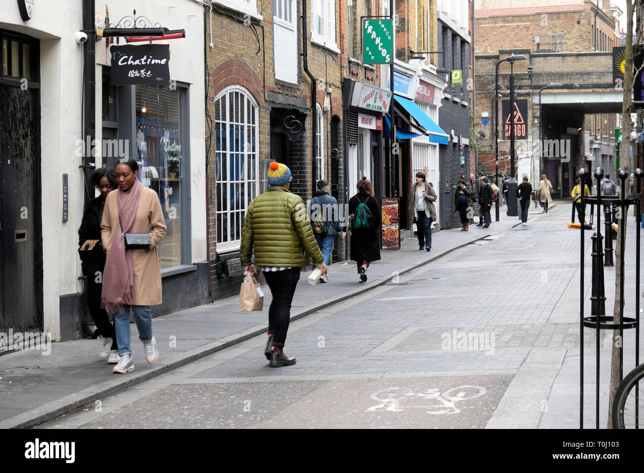 La gente cammina lungo Rivington Street passando accanto alle boutique a febbraio Shoreditch East London UK KATHY DEWITT Foto Stock