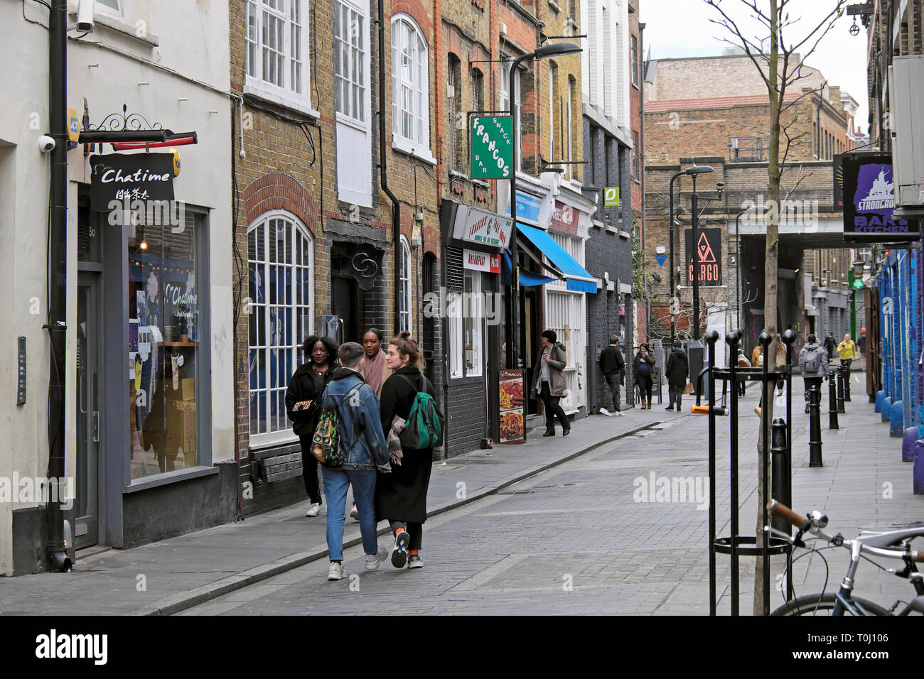 La gente camminare lungo Rivington Street passato negozi boutique in Shoreditch East London REGNO UNITO KATHY DEWITT Foto Stock