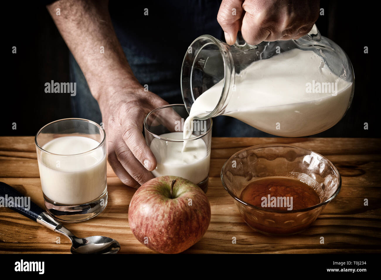 Versare il latte fresco in bicchieri - dissaturato effetto - messa a fuoco selettiva - primo piano Foto Stock